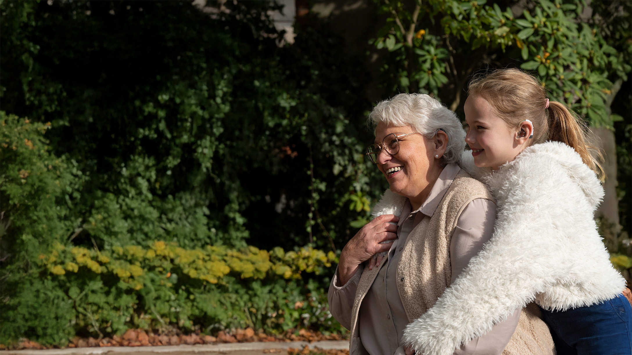 oma mit hörgerät und enkelin mit cochlea implantat glücklich